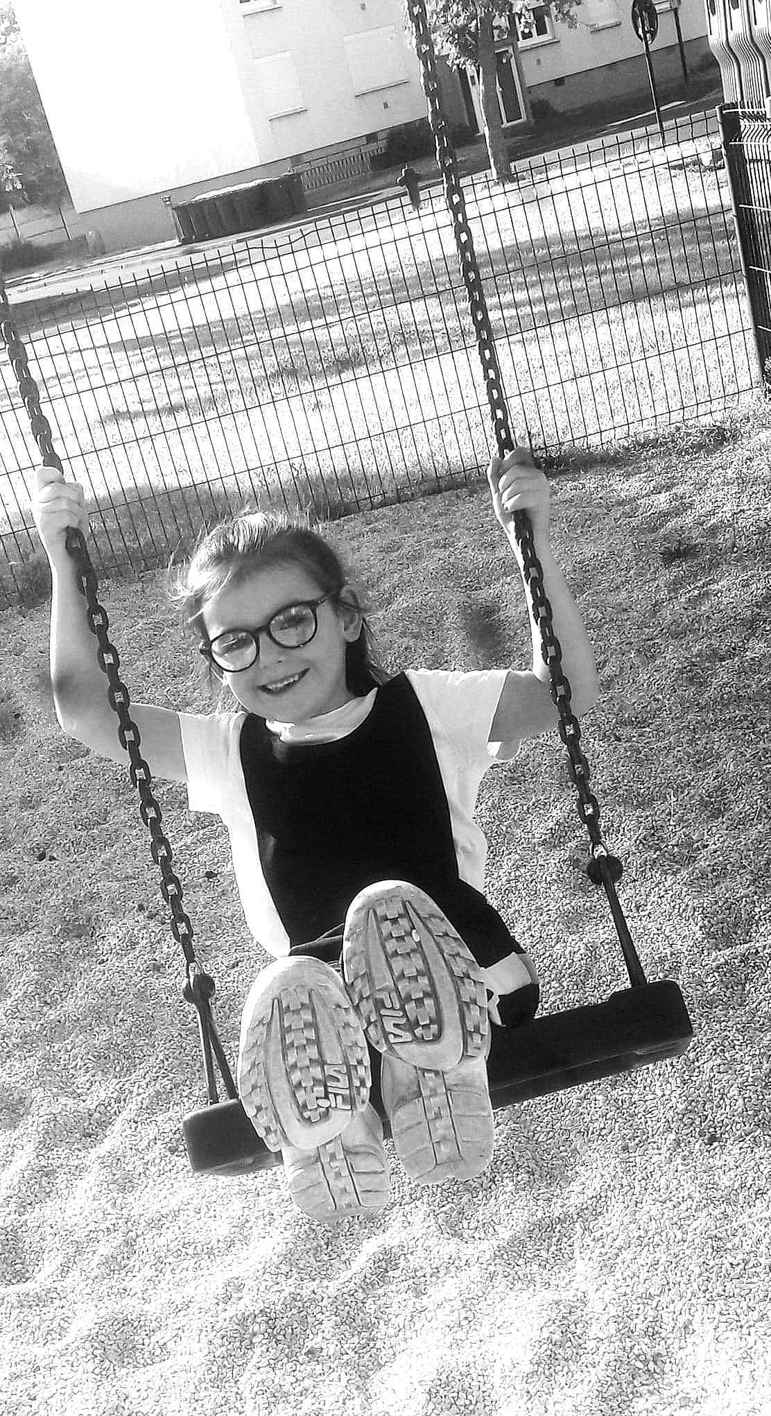 Mélyna participe au concours pour gagner de l'argent avec cette photo : black, black_and_white, eyewear, fence, flash_photography, fun, glasses, hand, happy, joy, leg, leisure, mesh, monochrome, monochrome_photography, outdoor_play_equipment, person, playground, recreation, smile