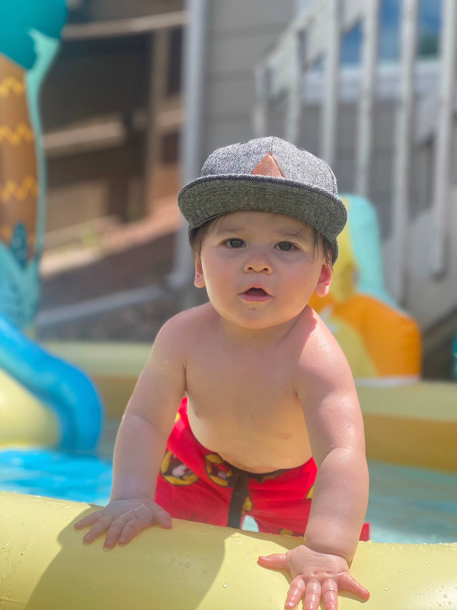 Keenan is registered to the contest to win money with this photo: baby, bathing, cap, chest, child, fun, happy, hat, headwear, leisure, nonbuilding_structure, person, personal_protective_equipment, play, recreation, sitting, sun_hat, swimming_pool, thigh, toddler