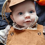 Albie joined the competition — help win amazing prizes! baby, child, scarecrow_costume, hat, corduroy_overall, pumpkin, blue_eyes, cute, portrait, indoors, fall, seasonal, smiling, face, person, plaid_shirt, button, closeup, soft_lighting, costume
