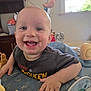 Joseph is registered to the contest to win money with this photo: baby, smile, face, child, toy, indoor, activity_center, happy, clothing, furniture, window, hand, head, eyes, mouth, cheeks, shirt, home, play, infant