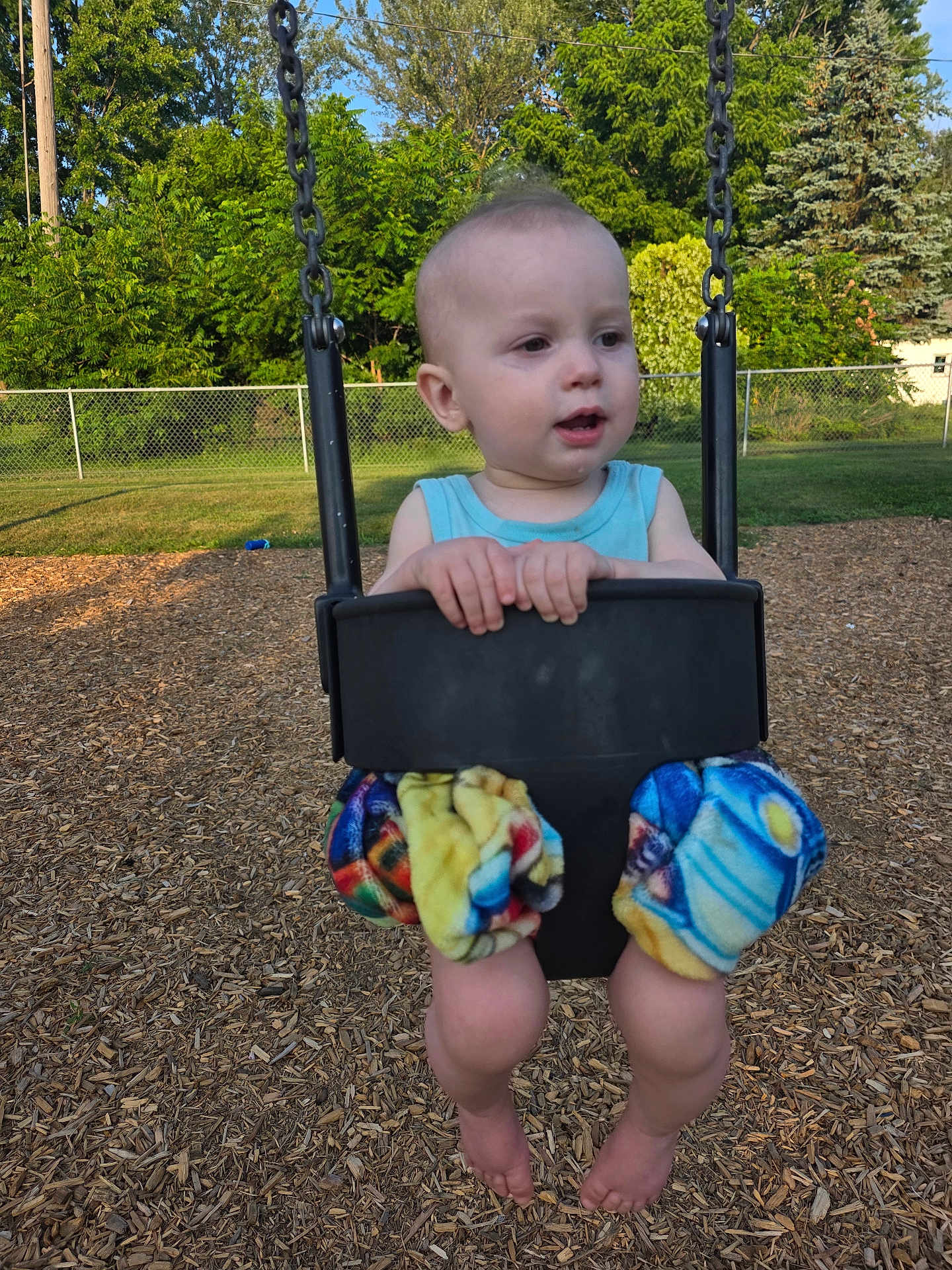 Joseph joined the competition — help win amazing prizes! toddler, child, swing, playground, outdoor, trees, grass, fence, sunlight, summer, legs, barefoot, colorful_clothing, happy, nature, daytime, park, play, fun, baby
