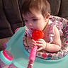 Raven is registered to the contest to win money with this photo: baby, child, toddler, sitting, activity_seat, toy, red_toy, colorful, indoors, couch, portrait, face, eyes, hair, hands, smiling, playtime, infant, furniture, home