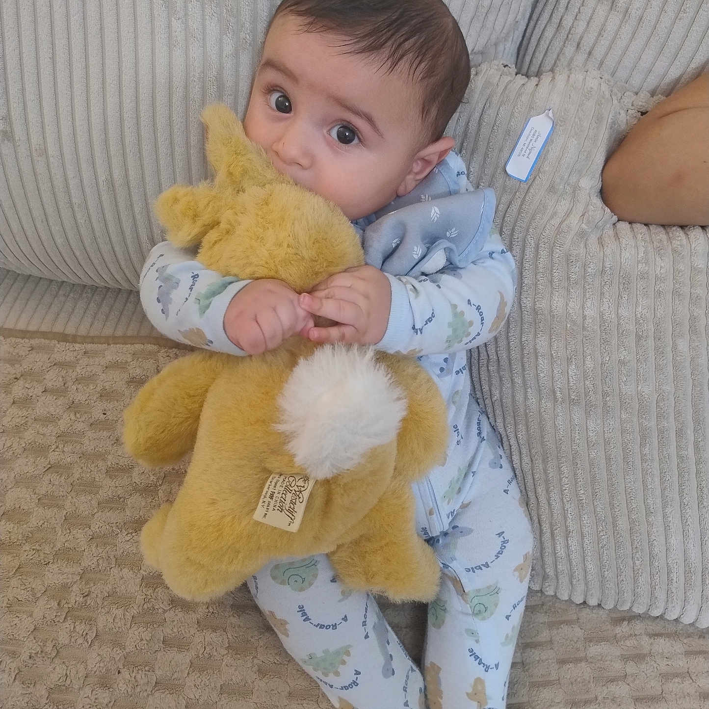 Karm joined the competition — help win amazing prizes! baby, child, stuffed_animal, plush_toy, couch, pajamas, indoor, cute, soft_toy, infant, seated, cozy, childhood, looking_up, home, comfort, fabric, cushion, toy, relaxation