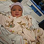 Luna is registered to the contest to win money with this photo: baby, infant, bed, hospital, blanket, clothing, onesie, hat, face, person, newborn, lying_down, sleepwear, cute, indoor, soft, comfort, resting, portrait, child