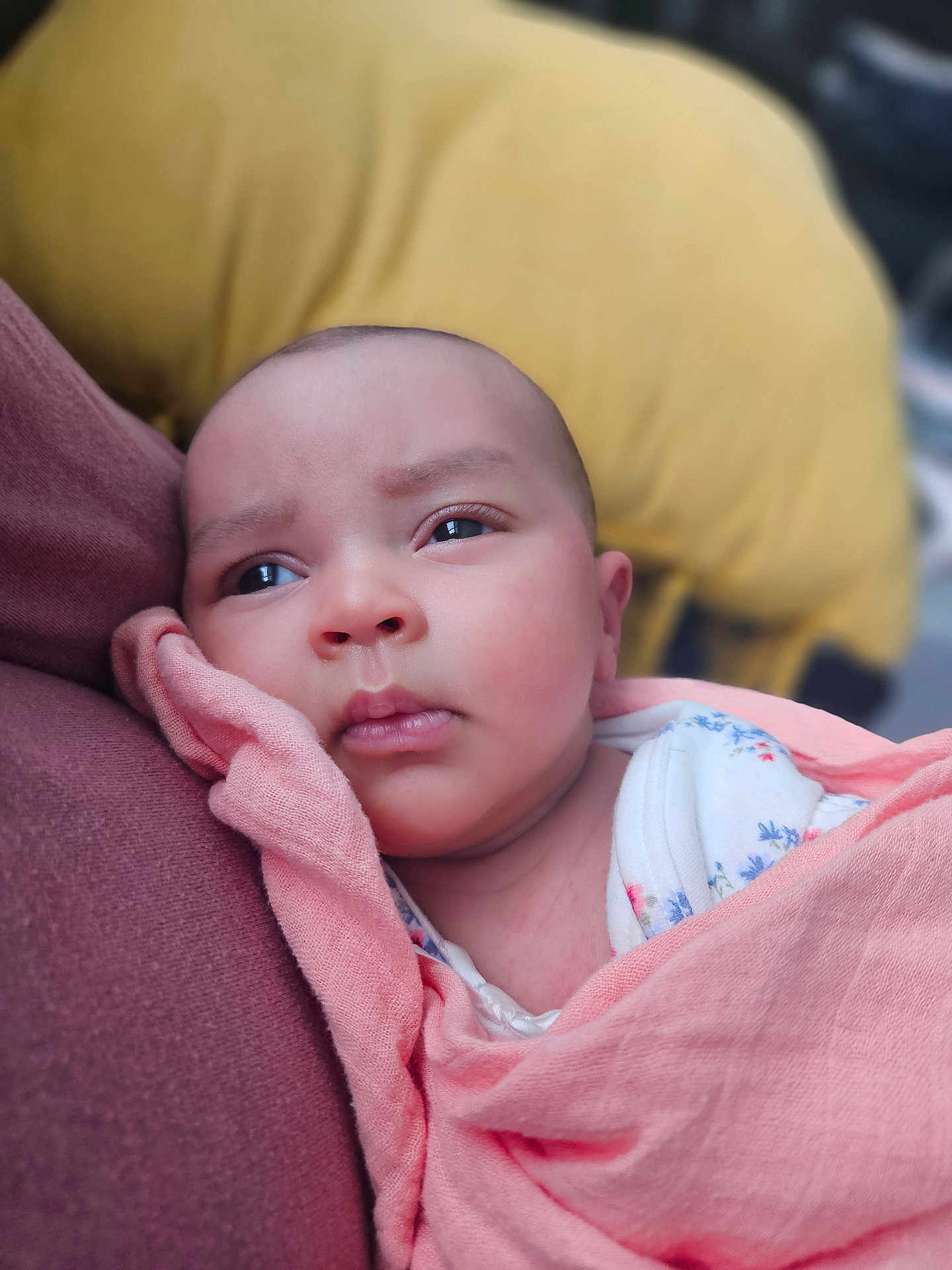 Luna is registered to the contest to win money with this photo: baby, infant, close_up, blanket, swaddled, face, expression, curious, resting, soft_texture, maroon, yellow_cushion, indoors, newborn, person, skin, head, clothing, portrait, sleepy