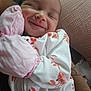 Luna is registered to the contest to win money with this photo: baby, smiling, infant, mittens, onesie, crab_print, cuddling, cute, sleepy, face, handwear, clothing, child, person, indoor, happy, closeup, soft, cozy, newborn