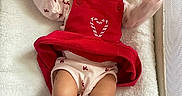 Harmony joined the competition — help win amazing prizes! baby, infant, child, portrait, lying_down, crib, blanket, red_outfit, heart, pink_socks, smiling, wide_eyed, arms_raised, indoor, nursery, cozy, textile, bedding, crib_mesh, photography