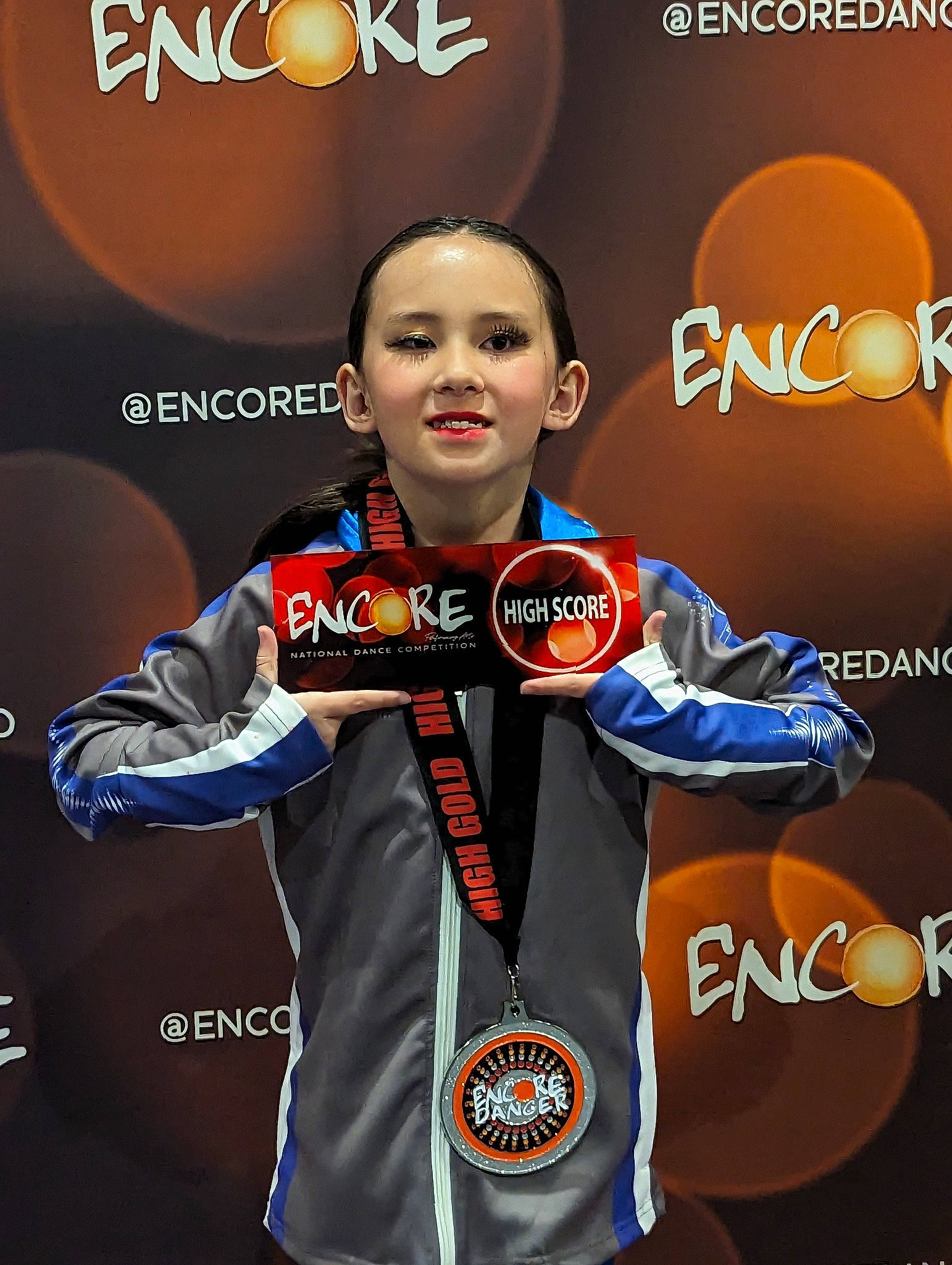 Olivia is registered to the contest to win money with this photo: advertising, brand, championship, electric_blue, fashion_design, font, gesture, graphics, individual_sports, logo, medal, person, sleeve, sports, sports_uniform, sportswear, uniform