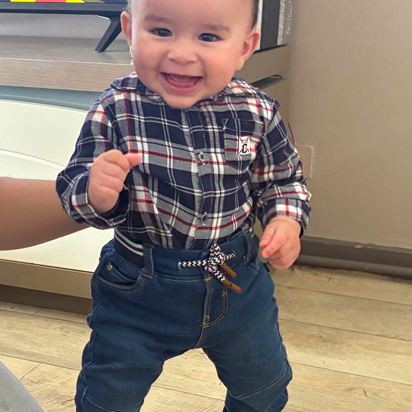 Akif participe au concours pour gagner de l'argent avec cette photo : baby, black_shoes, casual, child, clothing, cute, denim_pants, fashion, hand, happy, indoor, person, plaid_shirt, portrait, smiling, socks, standing, toddler, wooden_floor, young_child