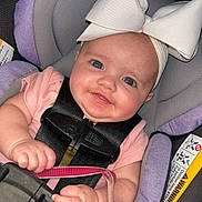 Kaylee is registered to the contest to win money with this photo: baby, child, car_seat, headband, bow, pacifier, smiling, infant, pink_clothing, seatbelt, safety, cute, portrait, closeup, hand, face, eyes, indoors, baby_accessory, child_safety
