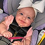 baby, child, car_seat, headband, bow, pacifier, smiling, infant, pink_clothing, seatbelt, safety, cute, portrait, closeup, hand, face, eyes, indoors, baby_accessory, child_safety