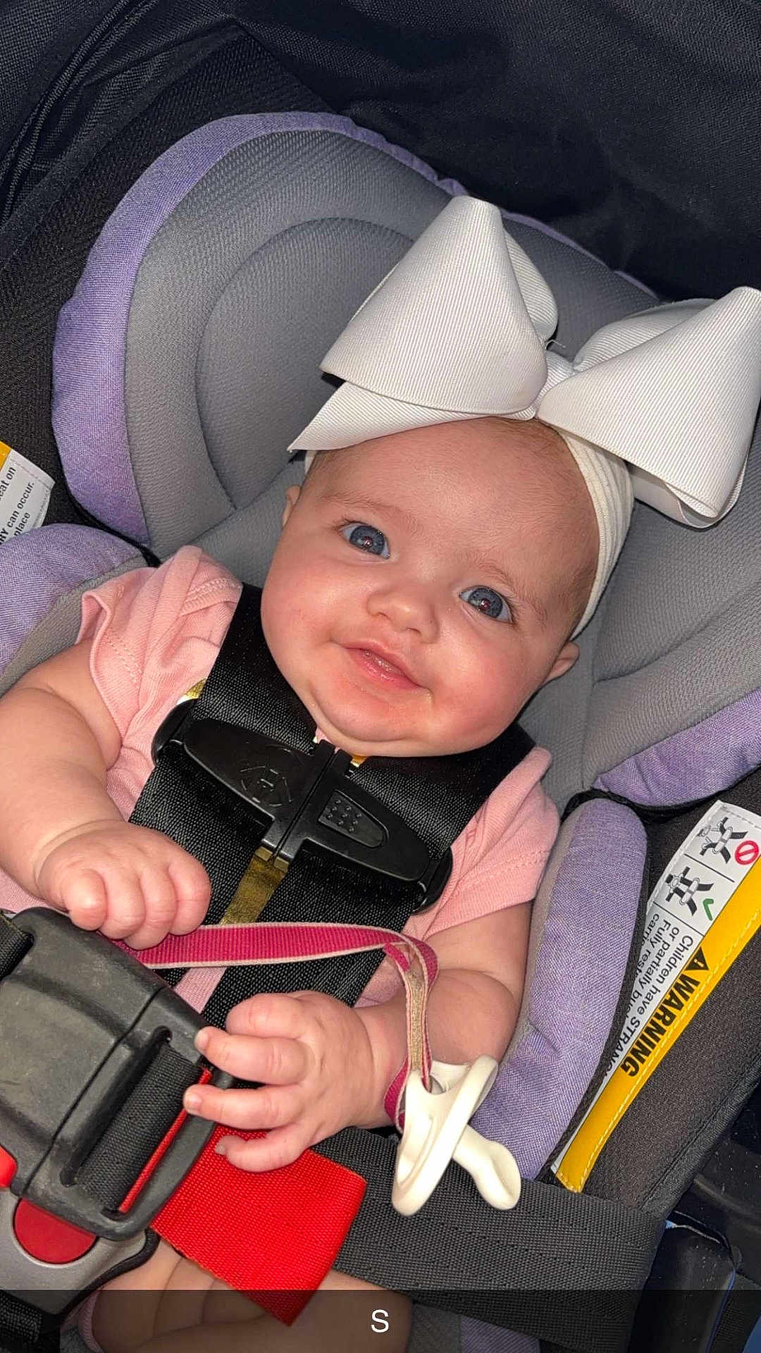 Kaylee is registered to the contest to win money with this photo: baby, child, car_seat, headband, bow, pacifier, smiling, infant, pink_clothing, seatbelt, safety, cute, portrait, closeup, hand, face, eyes, indoors, baby_accessory, child_safety