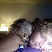 Thunder is registered to the contest to win money with this photo: bedroom, casual, closeup, comfort, dog, fur, home, human, indoor, lamp, light, pet, pillow, portrait, relaxed, resting, shoulder, sleepy, snuggling, woman