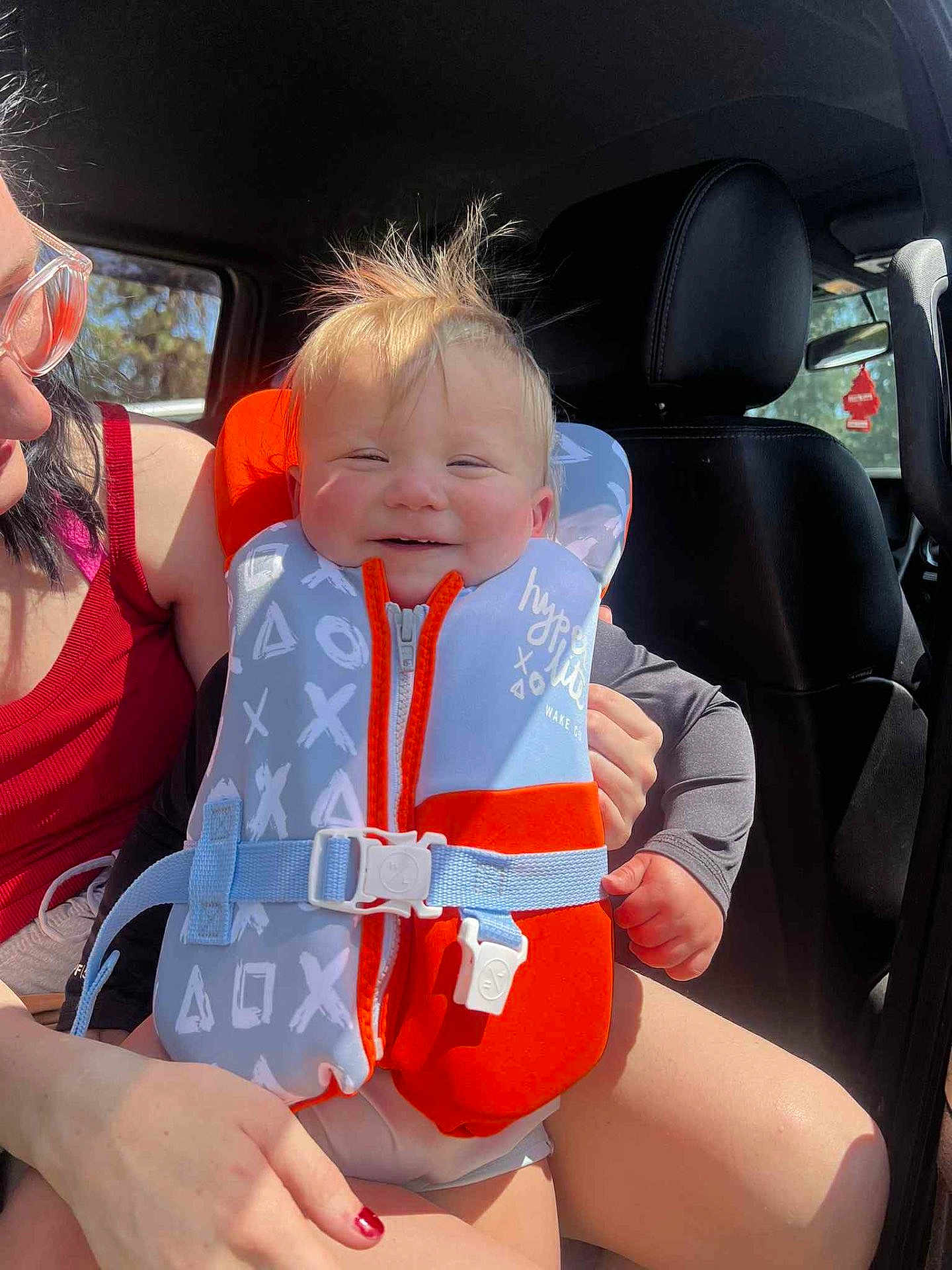 Summit joined the competition — help win amazing prizes! baby, child, life_jacket, car_interior, smiling, happy, person, seat, seatbelt, sunlight, hair, hand, clothing, window, adult, glasses, red_nail_polish, car_seat, safety, casual