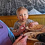 toddler, child, messy_face, chocolate, plate, cake, table, elderly_person, hand, nail_polish, food, indoor, wooden_table, curious, sitting, person, face, meal, family, bonding
