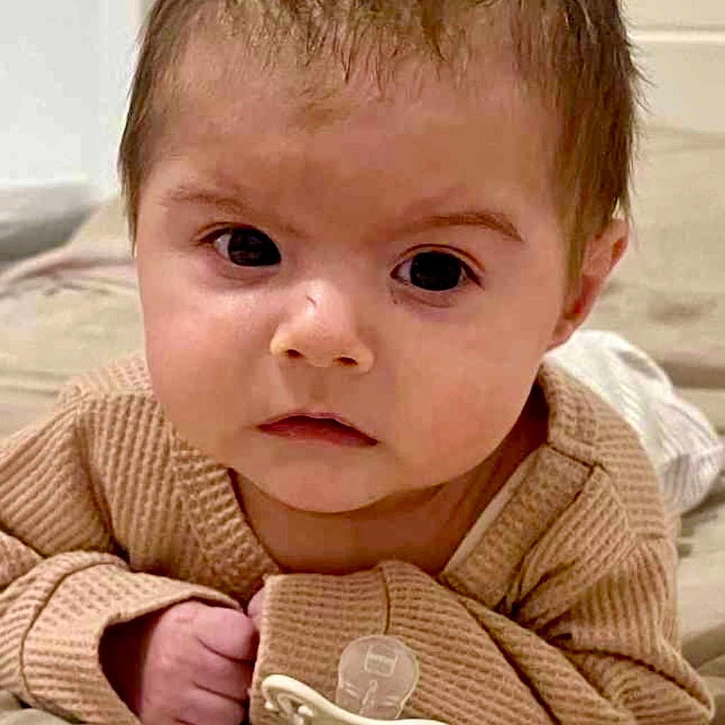 Cezar participe au concours pour gagner de l'argent avec cette photo : baby, child, closeup, cozy, cute, expression, face, hand, head, indoors, infant, looking, lying_down, pacifier, person, portrait, skin, soft_texture, sweater, young