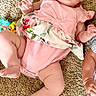 baby, infant, pink_outfit, carpet, child, cute, lying_down, floral_pattern, skin, hand, foot, face, expression, indoors, clothing, person, young_child, curious, real_photo, casual