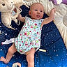 Bonnie is registered to the contest to win money with this photo: baby, infant, play_mat, plush_toy, rattle, onesie, child, cute, tongue_out, blue, floral_pattern, soft_toys, star_pattern, lying_down, reaching, floor, indoor, happy, curious, person