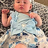 baby, infant, blue_dress, headband, flower_pattern, blanket, leopard_print, cute, child, indoors, soft_texture, portrait, newborn, clothing, fabric, person, laying_down, skin, face, expression
