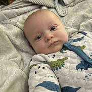 Kody joined the competition — help win amazing prizes! apparel, baby, blanket, child, closeup, cozy, cute, dinosaur_pattern, expression, face, head, indoor, infant, lying_down, onesie, plastic_cup, portrait, skin, sleepwear, soft_texture