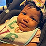 baby, infant, smile, face, headband, bow, bib, clothing, car_seat, seat, child, person, skin, hair, cute, sunlight, indoors, closeup, expression, happy