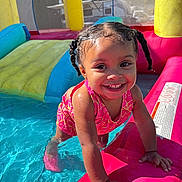 Lylah is registered to the contest to win money with this photo: toddler, child, smile, swimsuit, water, inflatable_pool, braided_hair, outdoor, sunlight, summer, play, fun, happy, pool, colorful, toy, splash, young_child, cute, person