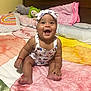 baby, bed, blanket, child, chubby_cheeks, clothing, colorful, cozy, cute, elephant_toy, frog_toy, happy, headband, indoors, infant, plush_toy, portrait, sitting, smile, warm_lighting