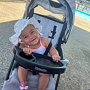 Mayalyn joined the competition — help win amazing prizes! baby, baby_clothing, bracelet, child, concrete, daytime, footwear, happy, outdoor, person, playful, pool, sandals, seat, smiling, stroller, summer, sun_hat, sunlight, toy