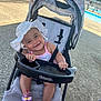 baby, baby_clothing, bracelet, child, concrete, daytime, footwear, happy, outdoor, person, playful, pool, sandals, seat, smiling, stroller, summer, sun_hat, sunlight, toy