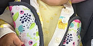 Mayalyn is registered to the contest to win money with this photo: baby, bow, bright, car_seat, child, close_up, colorful, cute, face, floral_pattern, hand, happy, headband, indoors, infant, patterned_clothing, seat_belt, sitting, smiling, yellow_clothing