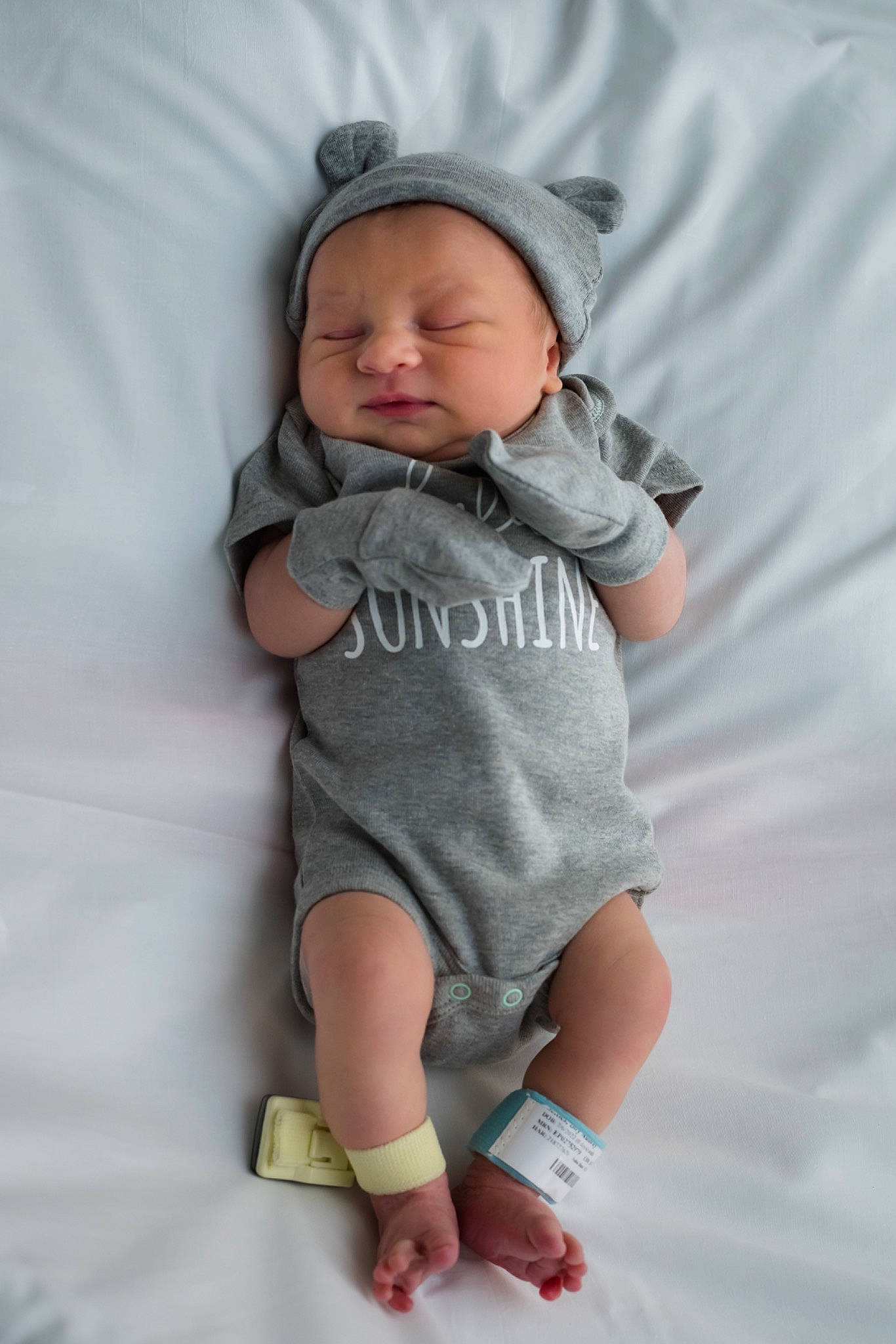 Carter is registered to the contest to win money with this photo: arm, baby, baby_toddler_clothing, cheek, child, comfort, face, finger, gesture, hand, hat, human_body, linens, pattern, person, pink, skin, sleeve, t_shirt, thumb