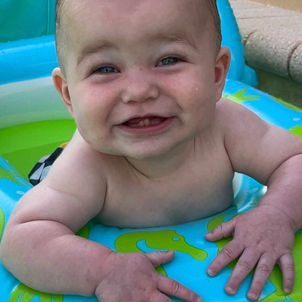 Carter is registered to the contest to win money with this photo: baby, blue, child, cute, float, fun, green, hands, happy, infant, inflatable, moawk, outdoor, person, playful, pool, skin, smiling, summer, water