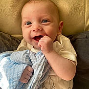 Theodore joined the competition — help win amazing prizes! baby, infant, smiling, blue_blanket, hand, face, eyes, mouth, clothing, white_outfit, cute, happy, indoor, soft_texture, skin, cheeks, fingers, seated, blanket, portrait