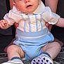 Theodore is registered to the contest to win money with this photo: baby, child, infant, person, sitting, shoes, mickey_mouse_pattern, blue_clothing, white_shirt, carpet, hand_holding, legs, feet, indoor, curious_expression, short_hair, cute, portrait, closeup, human