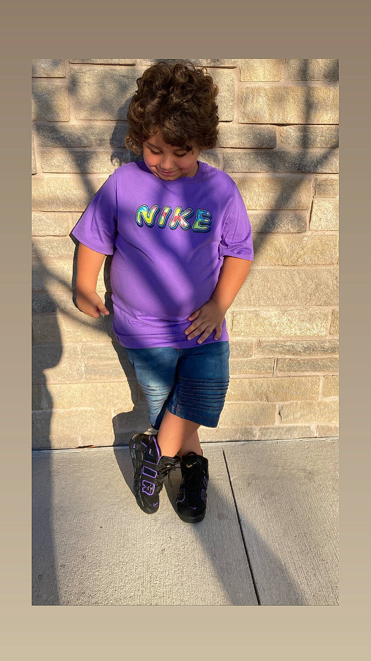 Jax is registered to the contest to win money with this photo: cool, denim, electric_blue, eyewear, fun, hair, happy, human_leg, joy, knee, magenta, outerwear, pattern, person, purple, sandal, sleeve, sportswear, t_shirt, thigh