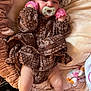 Dakota is registered to the contest to win money with this photo: baby, infant, pacifier, headband, mittens, brown_clothing, blanket, plush_toy, legs, feet, soft_fabric, lying_down, indoors, cute, child, newborn, patterned_clothing, comfort, sleepwear, resting