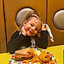 Lilly-Sue is registered to the contest to win money with this photo: child, girl, smiling, food, plate, curly_fries, sandwich, carrot, pizza, table, booth, hair, pigtails, snack, indoor, happy, colorful, casual, meal, seated