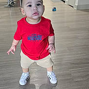 Juseph is registered to the contest to win money with this photo: toddler, child, indoor, red_shirt, beige_shorts, white_sneakers, floor, kitchen, cabinet, modern, curious, standing, person, young_child, home, interior, toy, bracelet, short_hair, expression