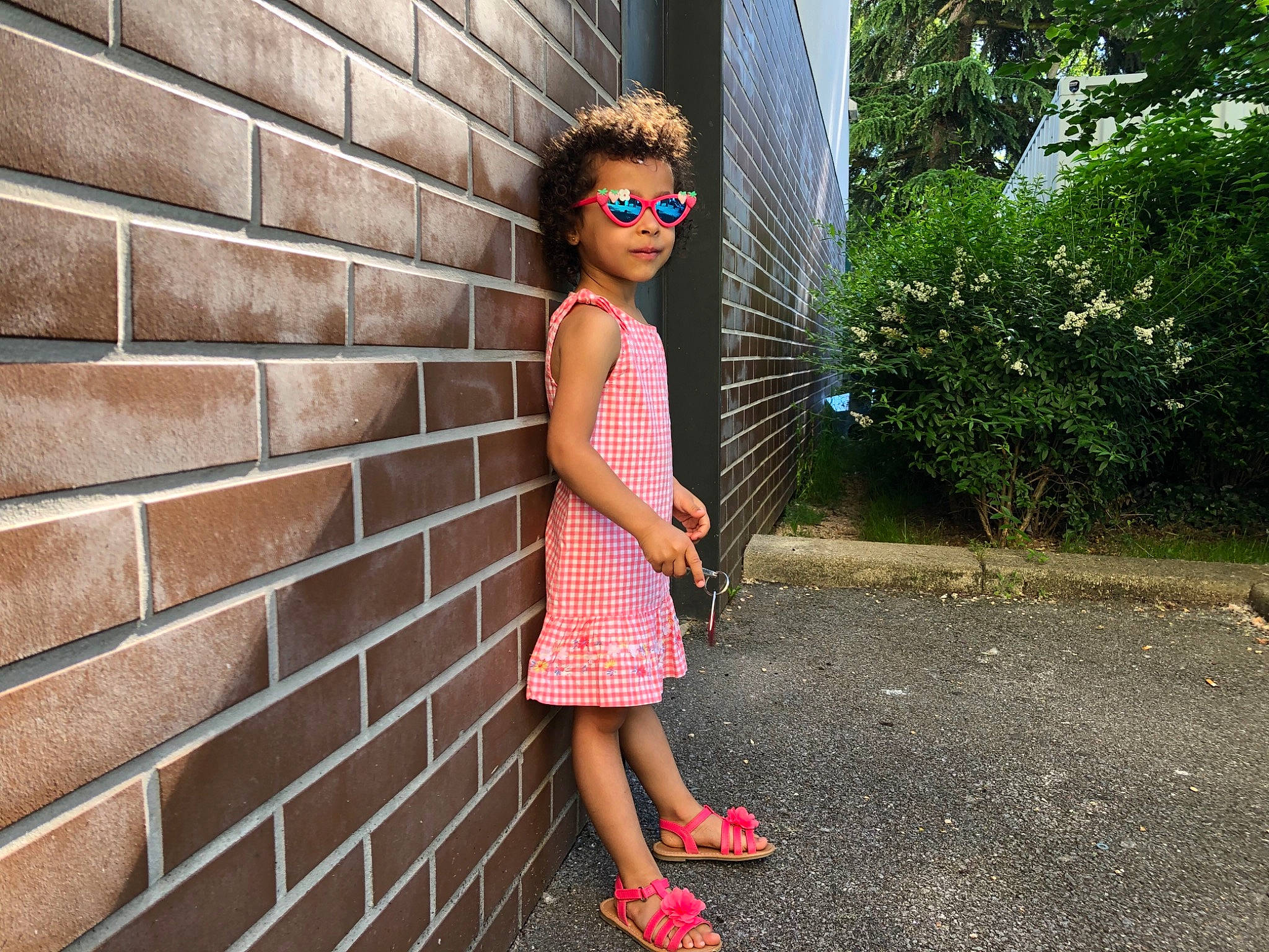 Miya participe au concours pour gagner de l'argent avec cette photo : asphalt, clothing, day_dress, eyewear, leisure, pattern, person, pink, plaid, plant, road_surface, sandal, sidewalk, street_fashion, summer, sunglasses, t_shirt, tints_and_shades, tree, vision_care
