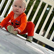 Allison joined the competition — help win amazing prizes! baby, background_blur, candid, casual, child, curious, daylight, expression, floor, hands, kneeling, orange_clothing, outdoor, person, playful, portrait, railing, sneakers, toddler, young_child