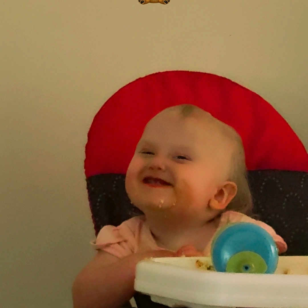 Allison is registered to the contest to win money with this photo: baby, child, cute, expression, face, feeding, food, furniture, happy, high_chair, indoor, infant, messy, person, playful, red_backrest, seat, smiling, toddler, toy