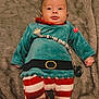 Ezio participe au concours pour gagner de l'argent avec cette photo : baby, infant, child, costume, elf, striped_pants, pacifier, blanket, fur, lying_down, red_heart, cute, clothing, toddler, indoors, warm_colors, feet, face, person, smiling