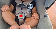 Karson is registered to the contest to win money with this photo: baby, bare_feet, buckled, car_seat, child, clothing, feet, gray, hands, harness, indoors, infant, photography, portrait, safety, sitting, travel, vehicle_equipment, wide_eyed, wood_floor