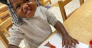 Cherish joined the competition — help win amazing prizes! child, toddler, classroom, craft, art_project, tree, paper, table, chair, school, preschool, braids, smiling, funny_face, sitting, indoors, 教育, colorful, drawing, portrait
