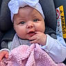 adorable, airbag_label, baby, bow, car_seat, cheeks, close_up, clothing, cozy, eyes, fingers, hand, harness, headband, infant, pink_blanket, portrait, seat, soft_texture, wide_eyed