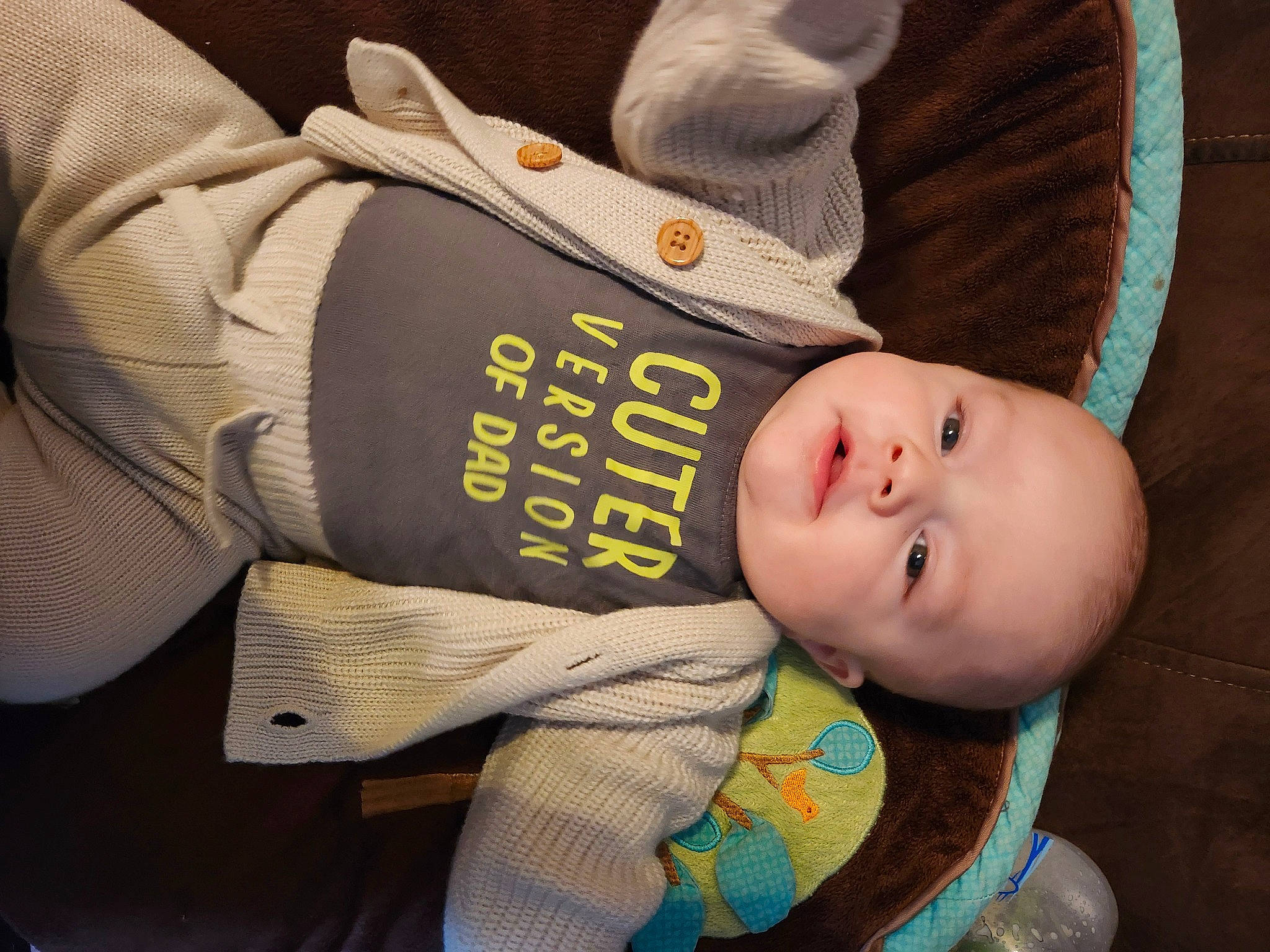Levi Axel is registered to the contest to win money with this photo: baby, baby_products, baby_safety, baby_sleeping, baby_toddler_clothing, beanie, cheek, child, comfort, font, headgear, human_body, pattern, person, personal_protective_equipment, sitting, sleeve, toddler, wood