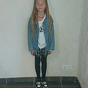 Lorna a rejoint le concours — aidez-le/la à gagner de superbes lots ! child, girl, denim_jacket, glasses, plaid_skirt, black_tights, sneakers, long_hair, pigtails, indoor, tiled_floor, plain_wall, standing, casual_clothing, portrait, young_person, fashion, wall_socket, minimalist, calm_expression