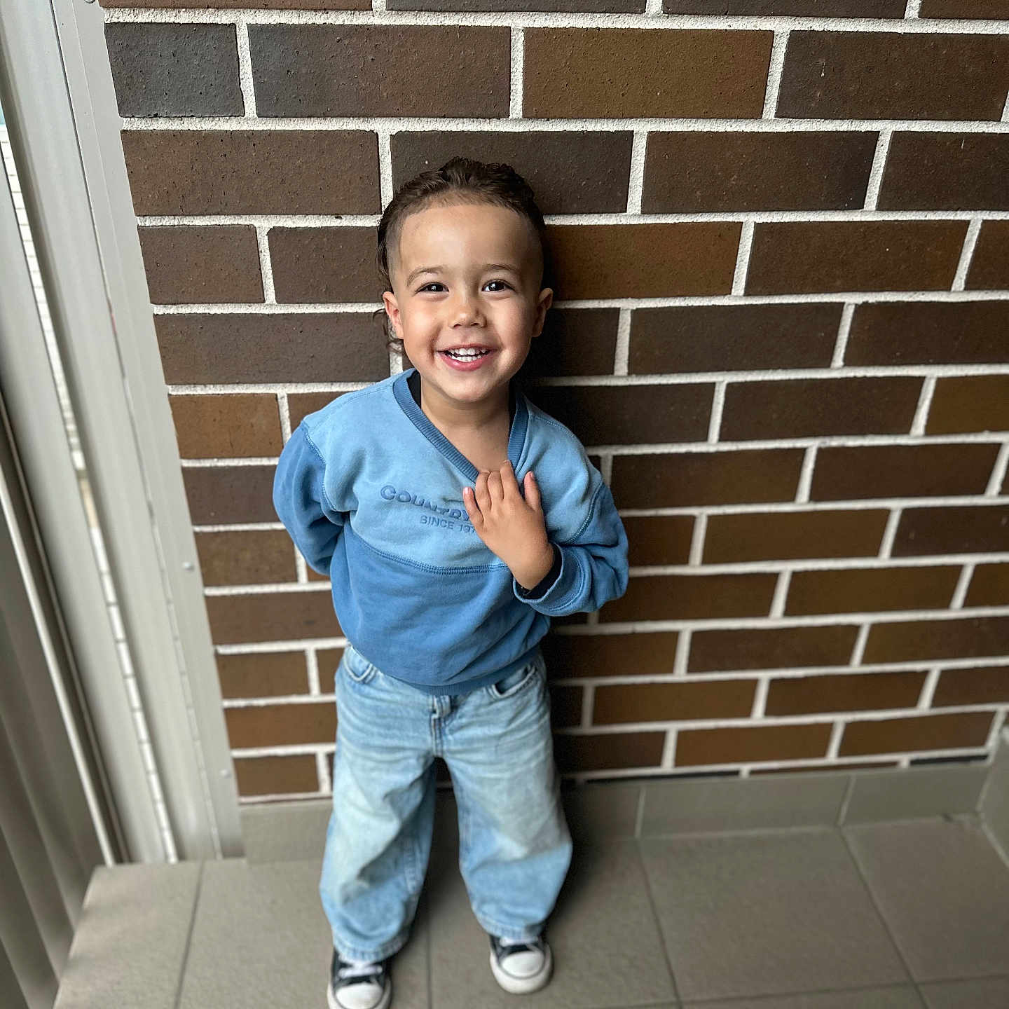 Zavian joined the competition — help win amazing prizes! architecture, boy, brick, building, child, clothing, coat, face, footwear, happy, head, jacket, jeans, male, pants, person, photography, portrait, smile, wall