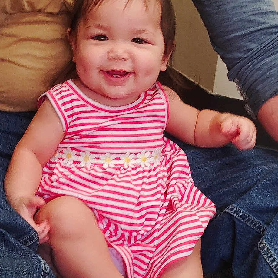 Avrianna is registered to the contest to win money with this photo: adult, baby, carpet, casual_clothing, child, cute, daisies, denim, family, feet, hair, hands, happy, indoor, legs, people, pony_tail, sitting, smiling, striped_dress