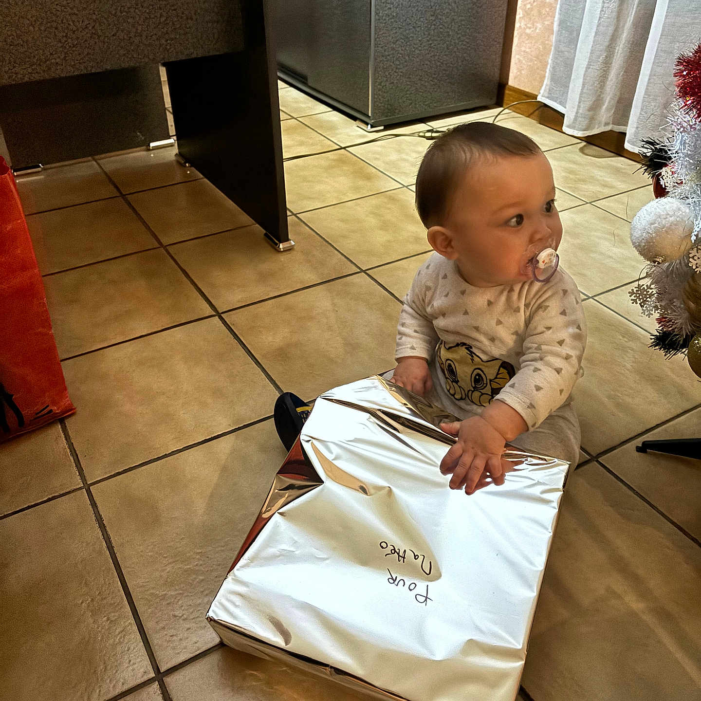 Matteo participe au concours pour gagner de l'argent avec cette photo : accessories, architecture, baby, bag, box, building, clothing, face, furniture, handbag, head, indoors, livingroom, openingpresent, pants, person, photography, portrait, room, sitting